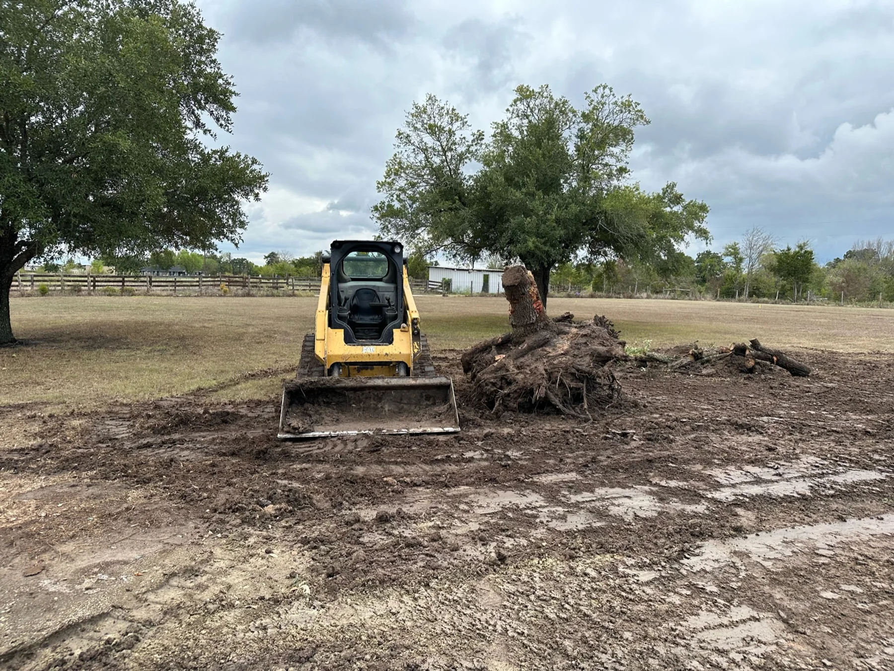 Double R skid steer clearing a property